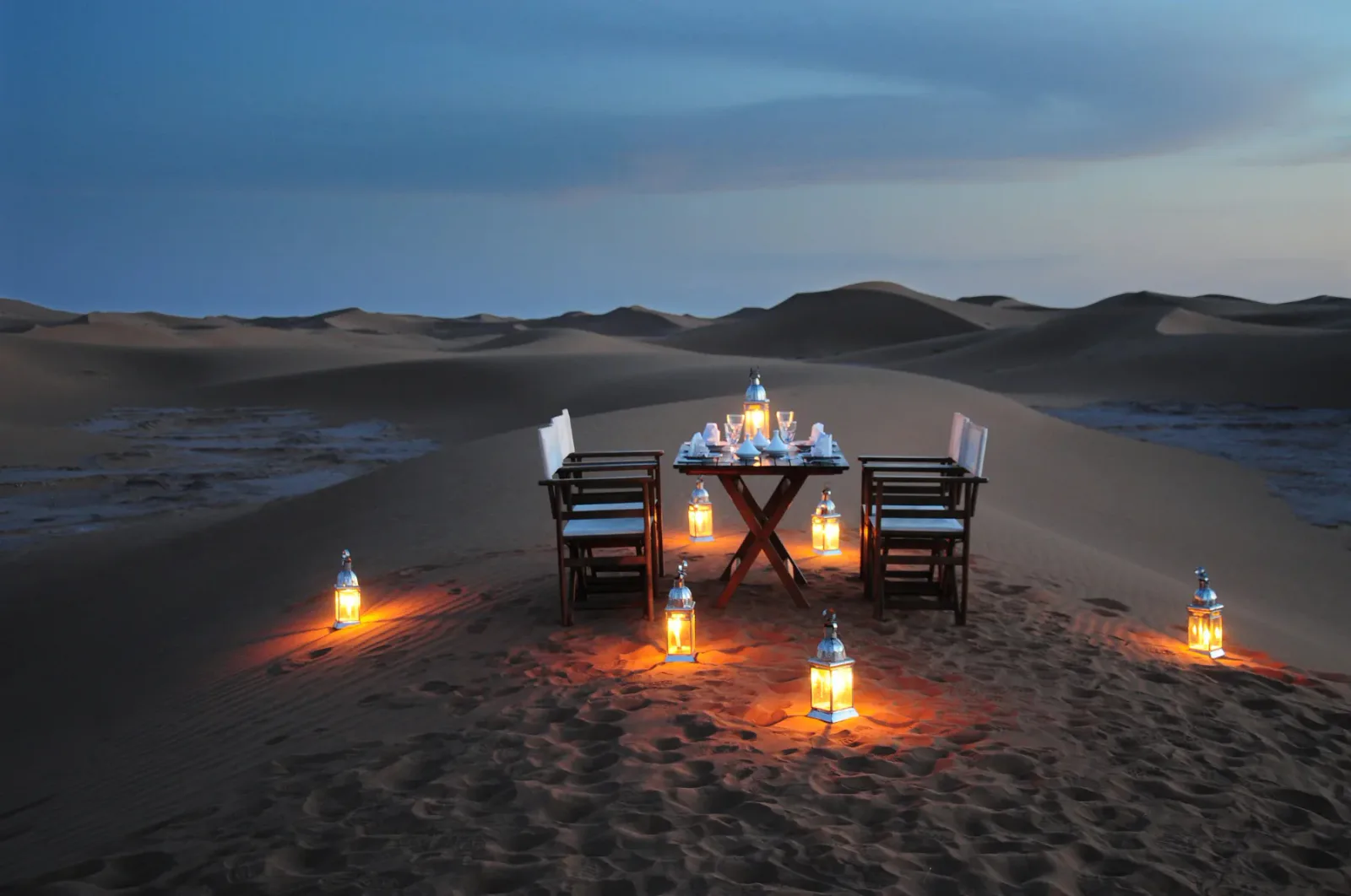 Velada iluminada por faroles entre las dunas marroquíes